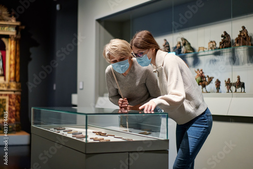 Woman and his daughter view the artworks