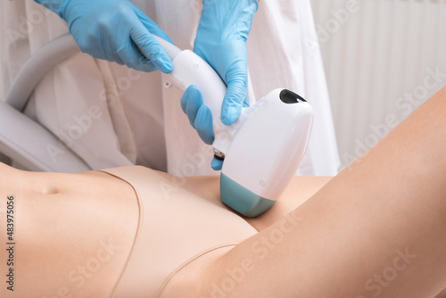 Elos epilation hair removal procedure on a woman   s body. Beautician doing laser rejuvenation on the lower leg in a beauty salon. Removing unwanted body hair. Hardware ipl cosmetology