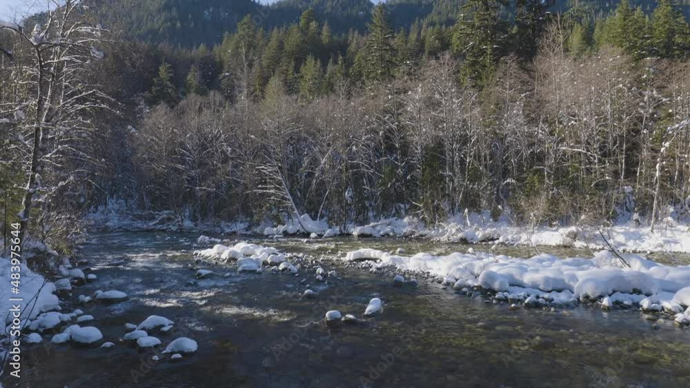 River in Canadian Nature, Trees in Forest, Winter Snow, Sunny Sky. Taken in Lynn Valley Canyon, North Vancouver, British Columbia, Canada. River in Canadian Nature, Trees in Forest, Winter Snow, Sunny Sky. Taken in Lynn Valley Canyon, North Vancouver, British Columbia, Canada.