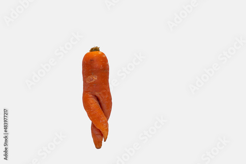 Deformed carrot resembling human body shape isolated on white photo