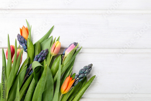 Colorful tulips and hyacinth flowers on wooden background.