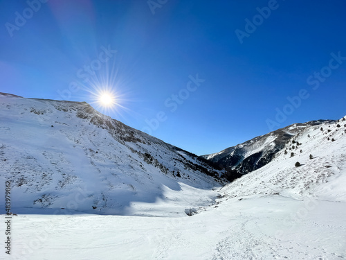 Picture of sun rising above the Nuria Valley mountains covered in snow at Catalan Pyrenees