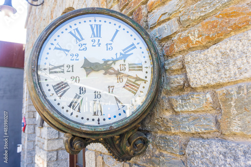 Vintage train clock on the old facade of Ribes Vila train stop. Picture made from rack railway on its way to Nuria Valley Sanctuary.