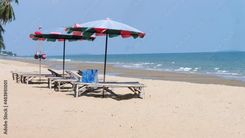 Two lounge chairs with sun umbrellas on a tropical beach in the clear sky, Summer vacation travel concept Two lounge chairs with sun umbrellas on a tropical beach in the clear sky, Summer vacation travel concept
