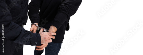 Close-up male hands in handcuffs. Policeman officer arrests a criminal isolated on white background. Concept of job, caree, safety. Security service. photo