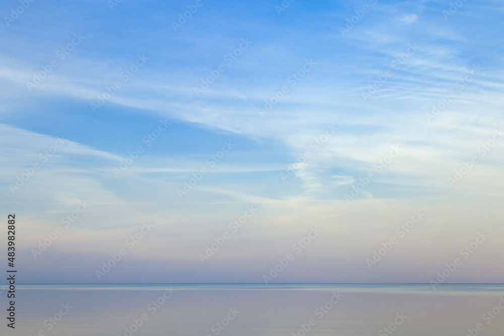 Fototapeta premium Beautiful sunset on sea, pastel colors and reflections on water, calm nature landscape with colorful clouds
