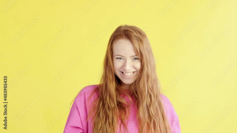 Red-haired young woman in a great mood is fooling around in studio on an isolated yellow background. female makes a mustache out of facial hair. Cheerful mood. Happy emotions of successful person Red-haired young woman in a great mood is fooling around in studio on an isolated yellow background. female makes a mustache out of facial hair. Cheerful mood. Happy emotions of successful person