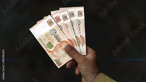 Singapore Dollar money holding. Fan of banknotes in hand. SGD paper cash. Concept of income, success, business, tax, economy and finance. photo