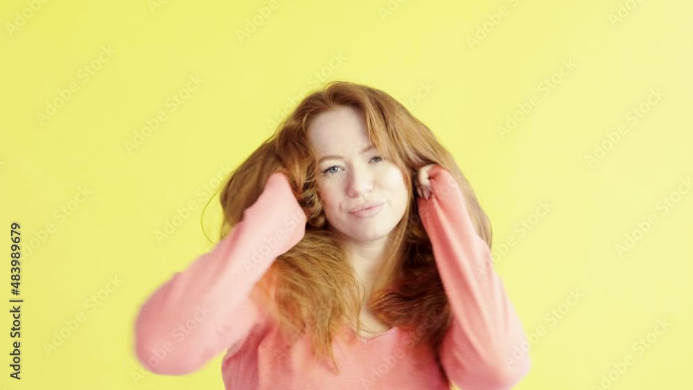 Studio portrait of beautiful young happy red-haired woman on yellow background. girl looks into camera, dances and enjoys life. Positive emotions in people's lives Studio portrait of beautiful young happy red-haired woman on yellow background. girl looks into camera, dances and enjoys life. Positive emotions in people's lives