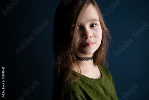 Portrait of a cute little 9 year old girl on dark background 