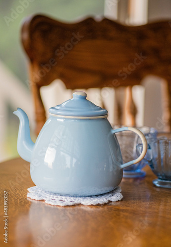 Vintage light blue tin teapot on oak table