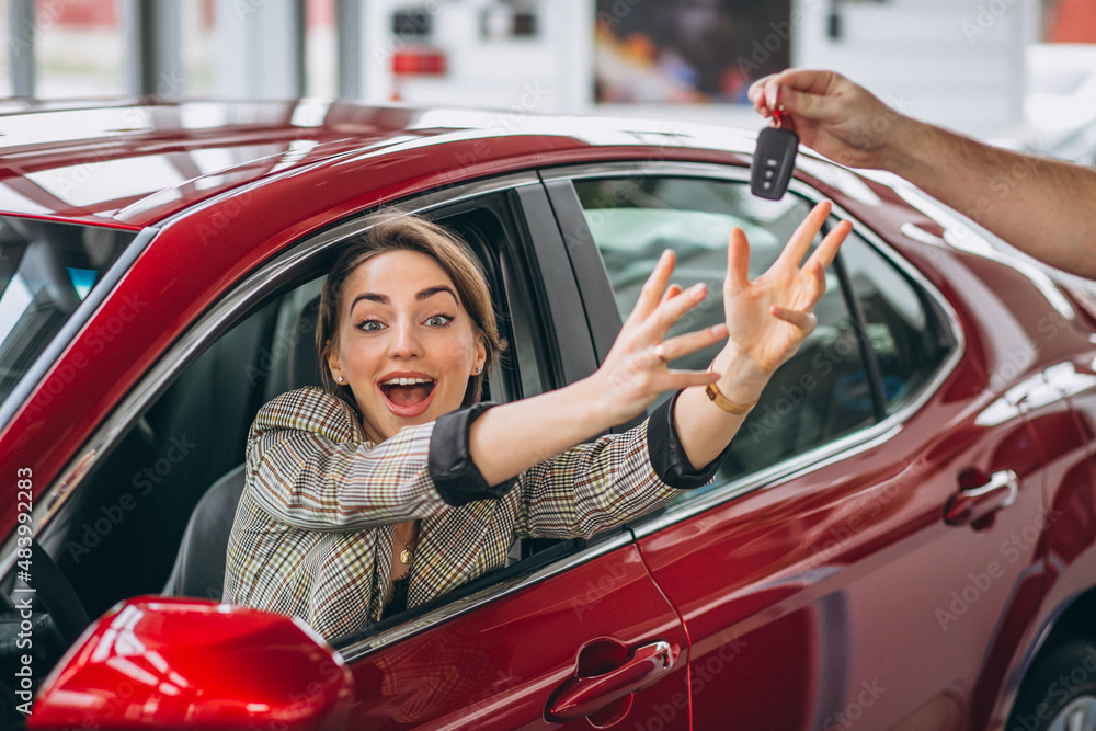 Woman sitting in red car and receiving keys