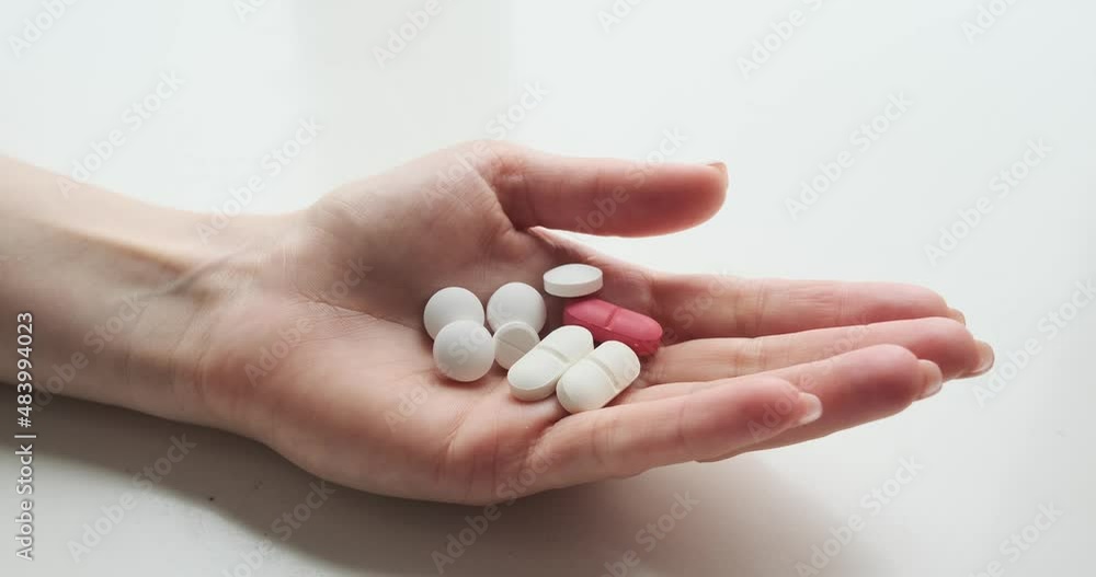 Hands of woman holding medicines over white background Hands of woman holding medicines over white background
