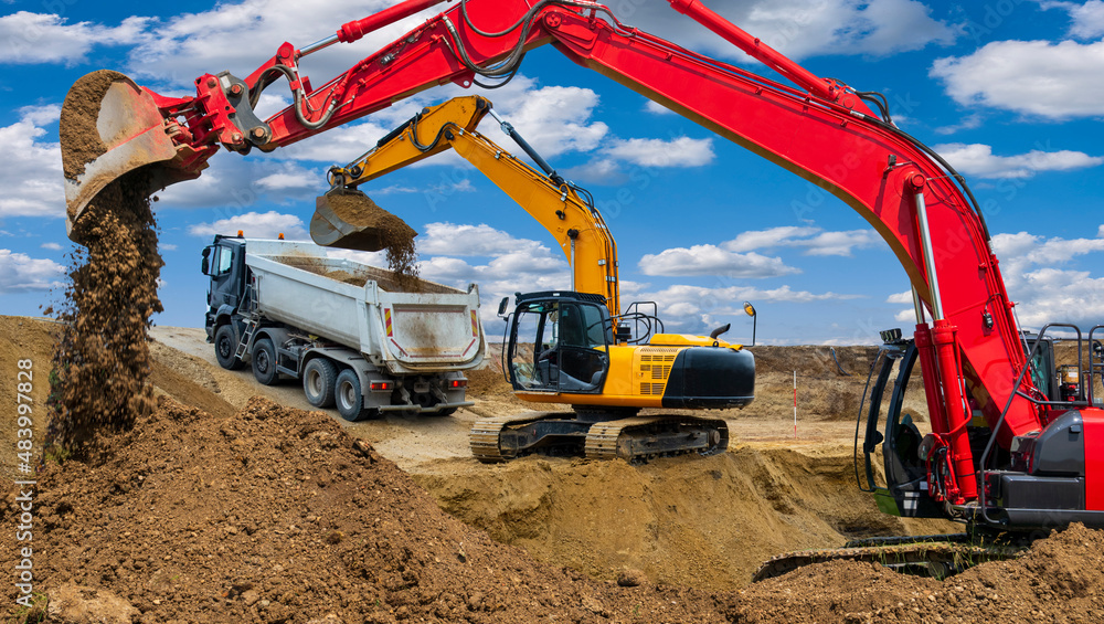 excavator working on construction site in front of dramatic sky Stock