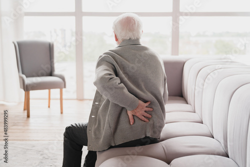 Obraz na plátne Senior old elderly man grandfather touching his back, suffering from backpain, sciatica, sedentary lifestyle concept