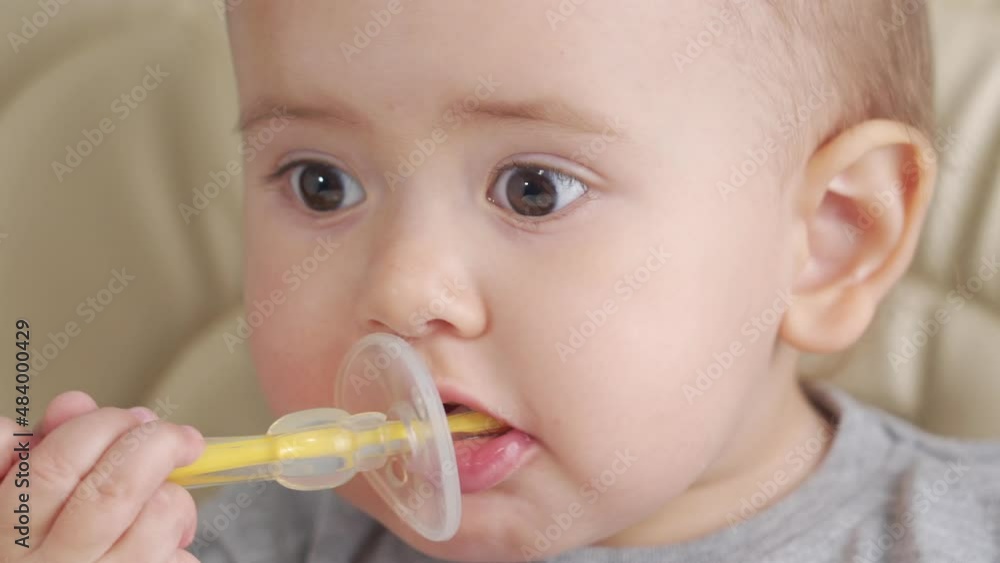 Toddler 12-25 months learning to brush teeth with silicone toothbrush, close-up Toddler 12-25 months learning to brush teeth with silicone toothbrush, close-up
