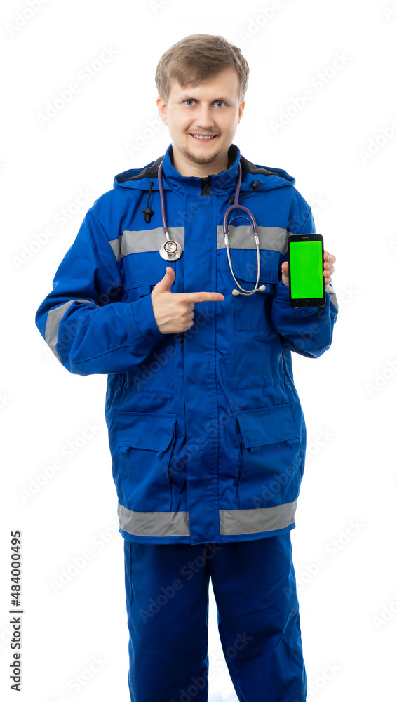 a man in a blue jacket and trousers holds a phone and points at it with his finger, a lifeguard smiles and looks at us. place for an inscription. isolated, white background a man in a blue jacket and trousers holds a phone and points at it with his finger, a lifeguard smiles and looks at us. place for an inscription. isolated, white background