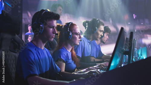 Foto Young and successful men and women professional gamers with coach playing video