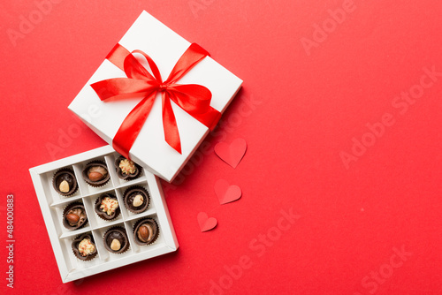 Delicious chocolate pralines in red box for Valentine's Day. Heart shaped box of chocolates top view with copy space © sosiukin