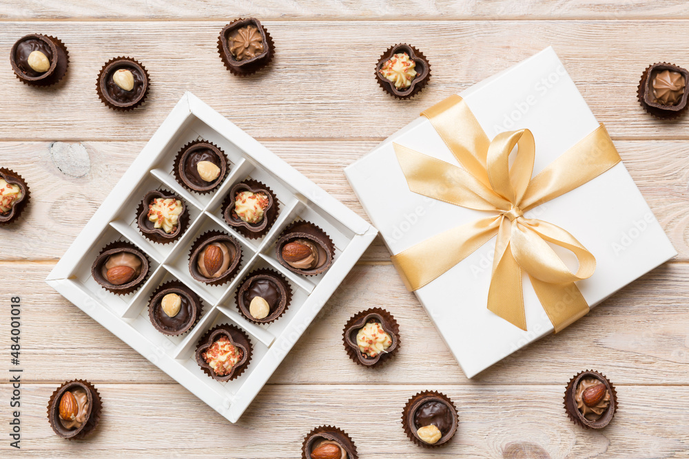 White box with chocolates candies and golden tape. top view with copy space White box with chocolates candies and golden tape. top view with copy space