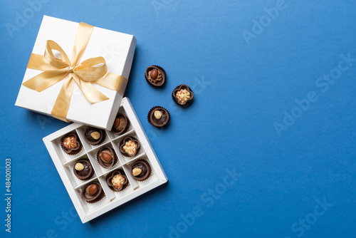 White box with chocolates candies and golden tape. top view with copy space © sosiukin