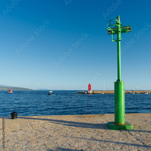 green Lighthouse at a pier in the port of Krk on the Adriatic Sea in Croatia