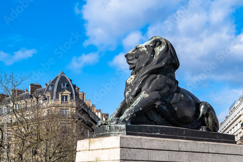 Paris, France, beautiful lion place Denfert-Rochereau in the 14e arrondissement, with typical buildings 