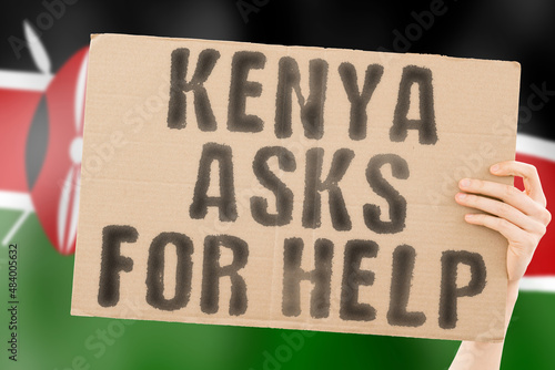 The phrase " Kenya asks for help " on a banner in men's hand with blurred Kenyan flag on the background. Battle. Combat. Tension. Voice. Aggression. Violence. Relationship. Society. Relation © AndriiKoval