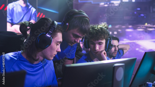 Obraz na płótnie Esportsman gamer in headsets listening to trainer explaining game strategy at st