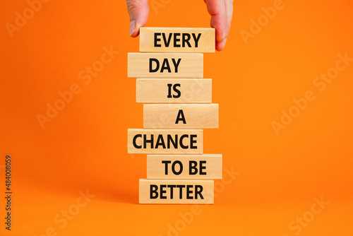 Chance to be better symbol. Wooden blocks with words Every day is a chance to be better. Beautiful orange background, copy space. Businessman hand. Business, motivational chance to be better concept. photo