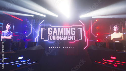 LED monitor with Gaming Tournament Grand Final inscription with spotlights and neon illumination in dark modern room with tables and computers