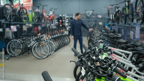 a man in business clothes chooses a bicycle in a sports store