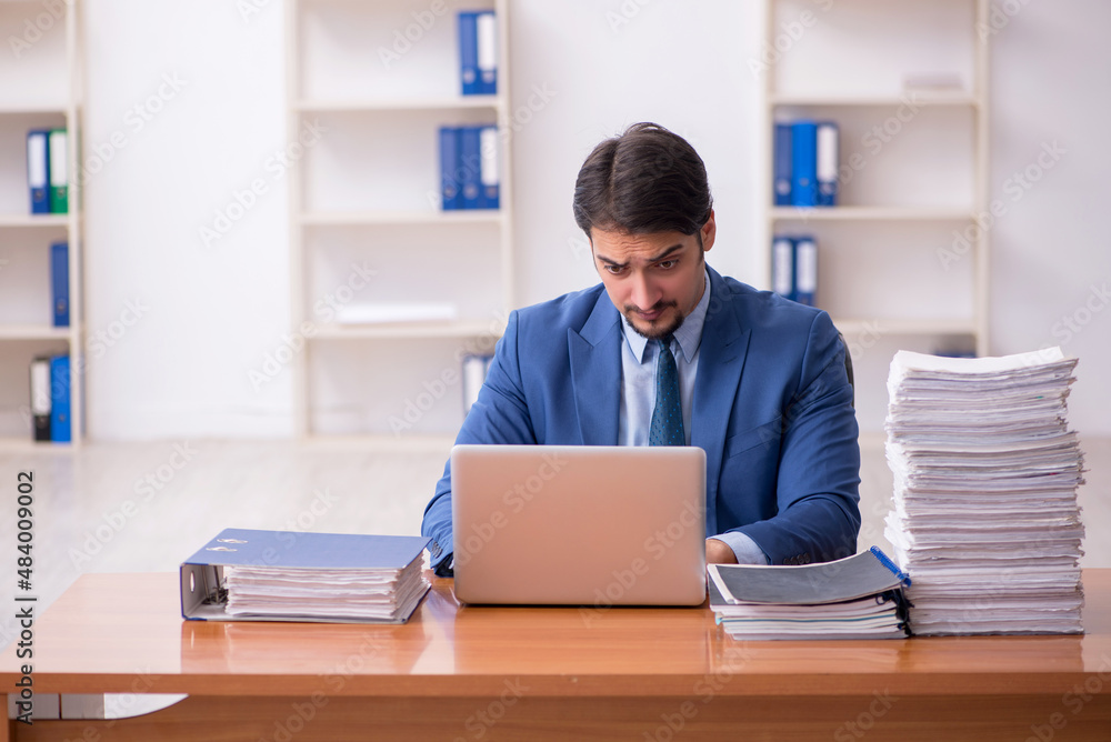 Young businessman employee and too much work in the office Young businessman employee and too much work in the office