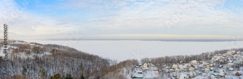 Panoramic winter landscape with wide Volga river and banks