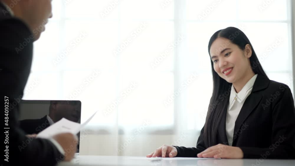 Smart asian woman shakes hands to greet a HR staff before a job interview to apply for a job. Happy woman seeker or insurance broker presenting a business deal. Business woman sending resume. Smart asian woman shakes hands to greet a HR staff before a job interview to apply for a job. Happy woman seeker or insurance broker presenting a business deal. Business woman sending resume.