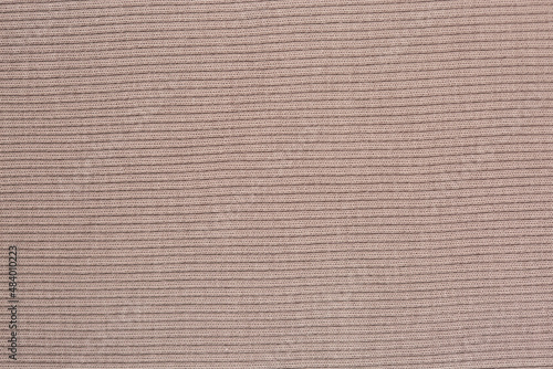 Texture of beige knitted sweater fabric.