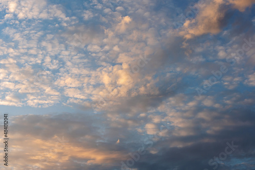 many wind-scattered cirrus clouds beautifully illuminated by the setting sun