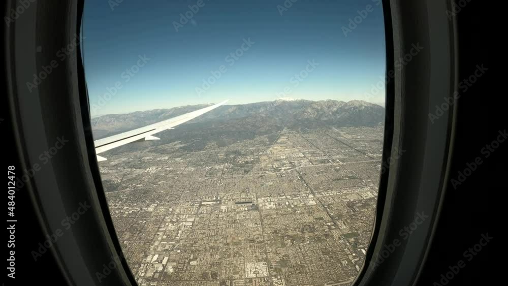 Aerial view from airplane window porthole during landing in Los Angeles, LAX. Beautiful view from airplane window. Ultra wide-angle POV shot from a window seat of an airplane. Aerial view from airplane window porthole during landing in Los Angeles, LAX. Beautiful view from airplane window. Ultra wide-angle POV shot from a window seat of an airplane.