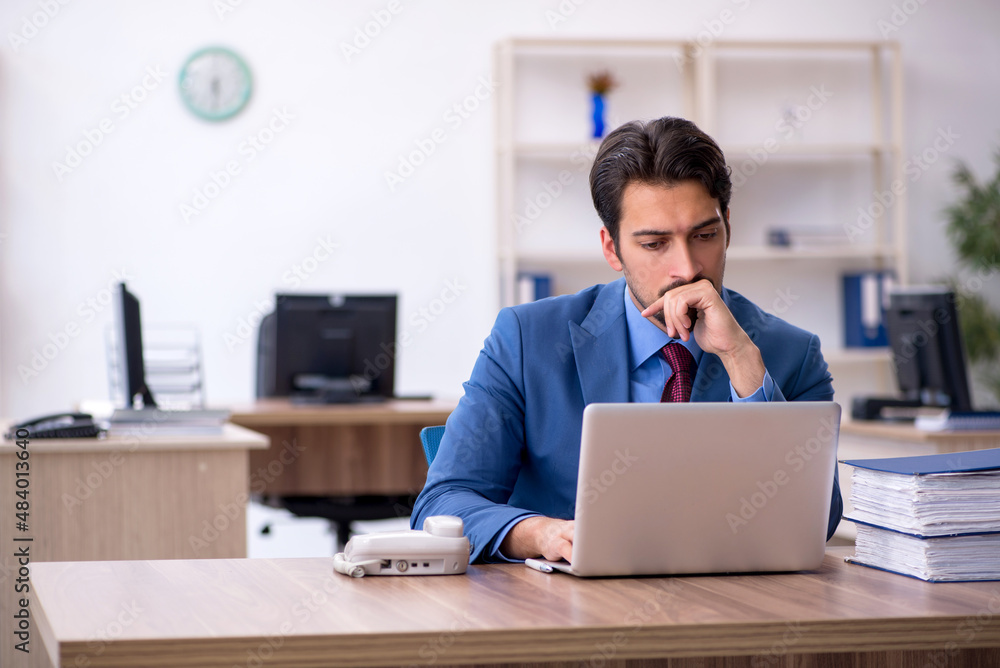 Young male employee working in the office Young male employee working in the office