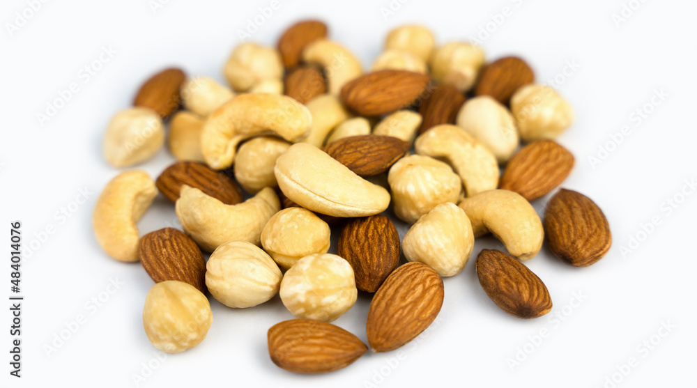 Mixed nuts almond, cashew, hazelnut isolated on white background. Close-up. Banner. Selective focus. Mixed nuts almond, cashew, hazelnut isolated on white background. Close-up. Banner. Selective focus.
