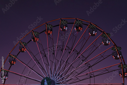 Fotografie Closeup colorful Ferris wheel against sunset very peri sky