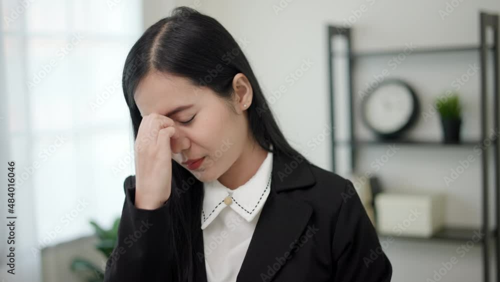 Office Syndrome. Close up shot. A business woman feeling stress from work. Business asian woman standing in office and treat his head on hands cause he get hurt from headache. 4k Resolution Office Syndrome. Close up shot. A business woman feeling stress from work. Business asian woman standing in office and treat his head on hands cause he get hurt from headache. 4k Resolution
