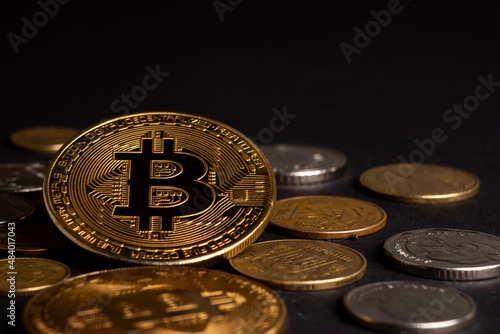 Close up of metal shiny bitcoin crypto currency coin with Ukrainian hryvnia coins. Electronic decentralized money concept. legalise Bitcoin and cryptocurrencies in Ukraine