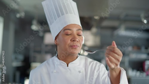 Restaurant Kitchen: Portrait of Black Female Chef Preparing Dish, Tasting Food and Enjoying it. Professional Cooking Delicious, Authentic, traditional Food, using Healthy Ingredients for Meal Recipe
