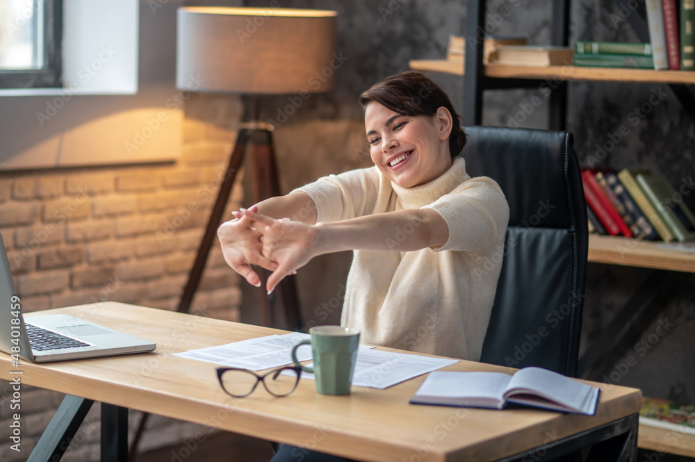 Ταπετσαρία Joyous young woman cracking her knuckles at the desk