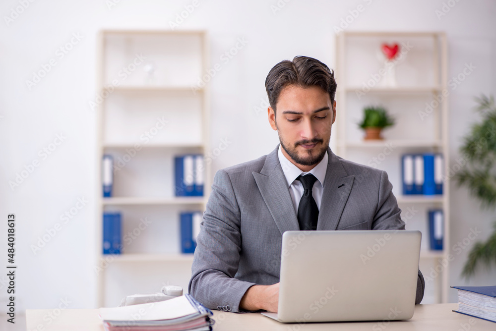 Young male employee working in the office Young male employee working in the office