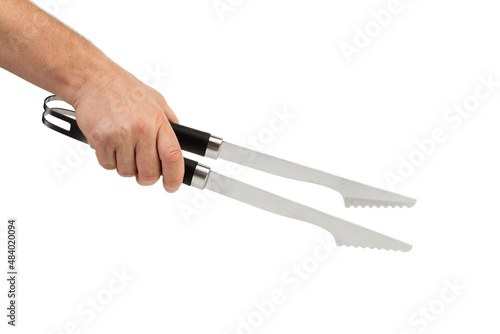 A hand holds a kitchen tong.