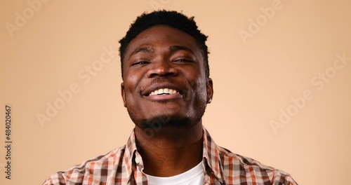 Happy African American man vlogging over beige background photo