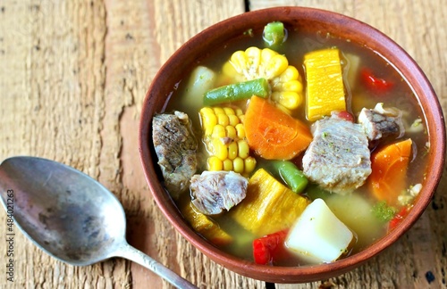 Mexican Beef Soup. Latin American soup with beef, potatoes, carrots, corn on the cob, green beans, peppers, Beef Broth,
copy space, place for text, country style  photo