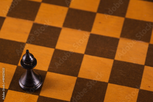 Bishop on a chessboard on a wooden background